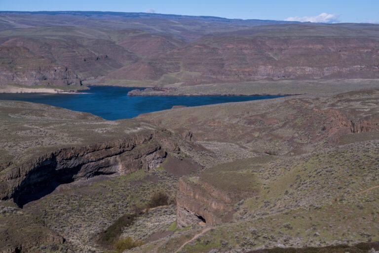 View across basalt cliffs to the turquoise Columbia River from The Perch near Quincy, Washington