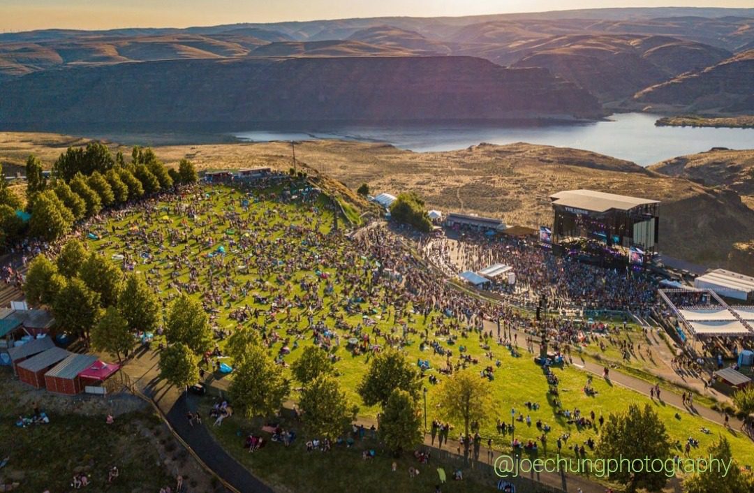 Aerial view of a packed Gorge Amphitheatre crowd overlooking the Columbia River at sunset near Quincy, Washington