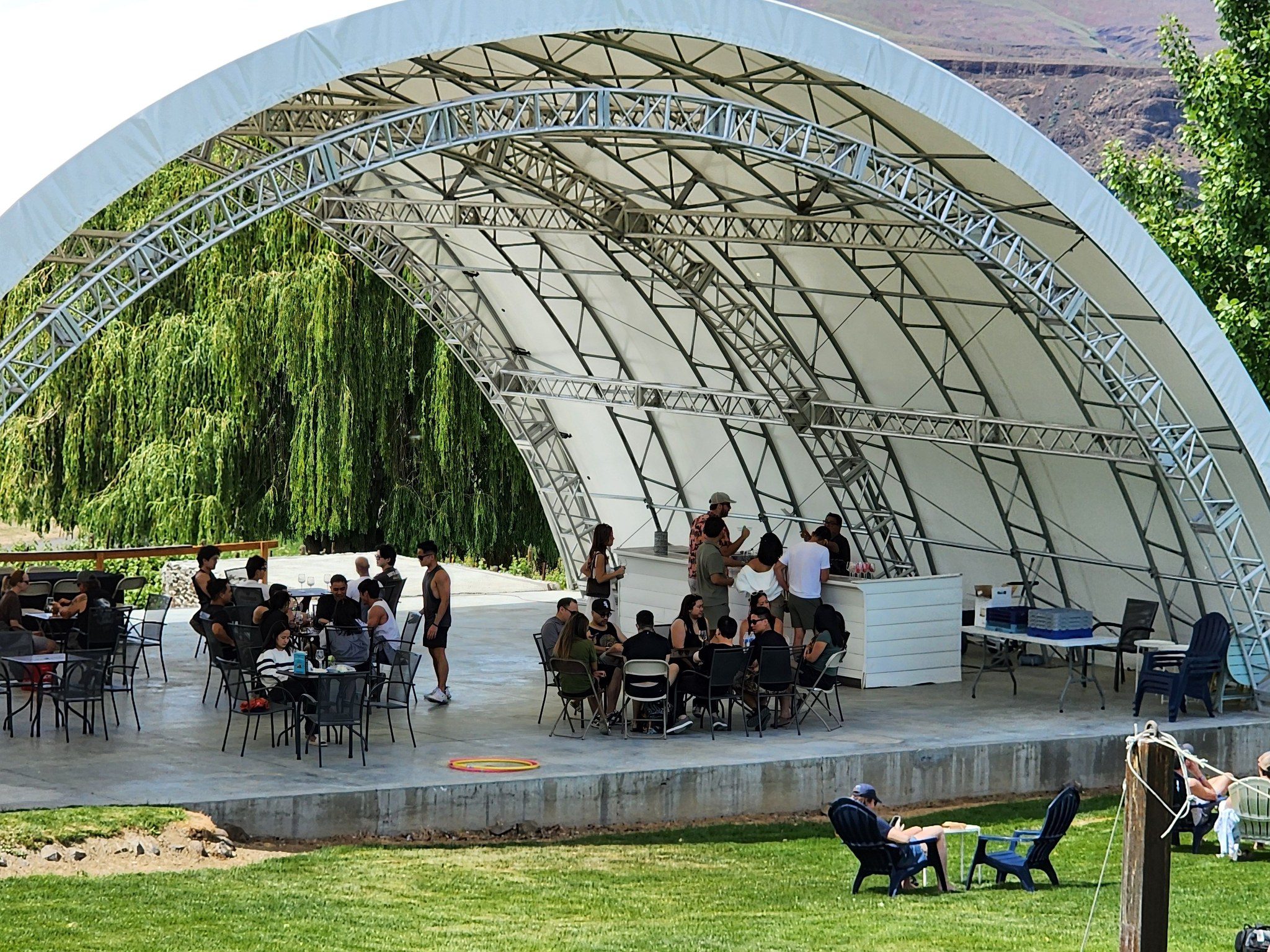 Guests seated at tables under the white arched pavilion canopy at Cave B near Quincy, Washington