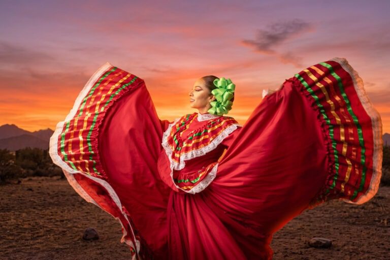 Ballet Folklórico dancer in a flowing red traditional dress at sunset